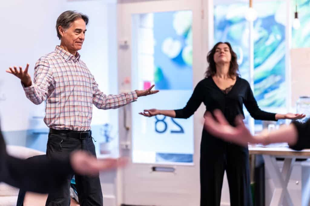 A somatic coach leads a small group of women through a grounding exercise at a Doors Open Embodied Leadership Retreat.